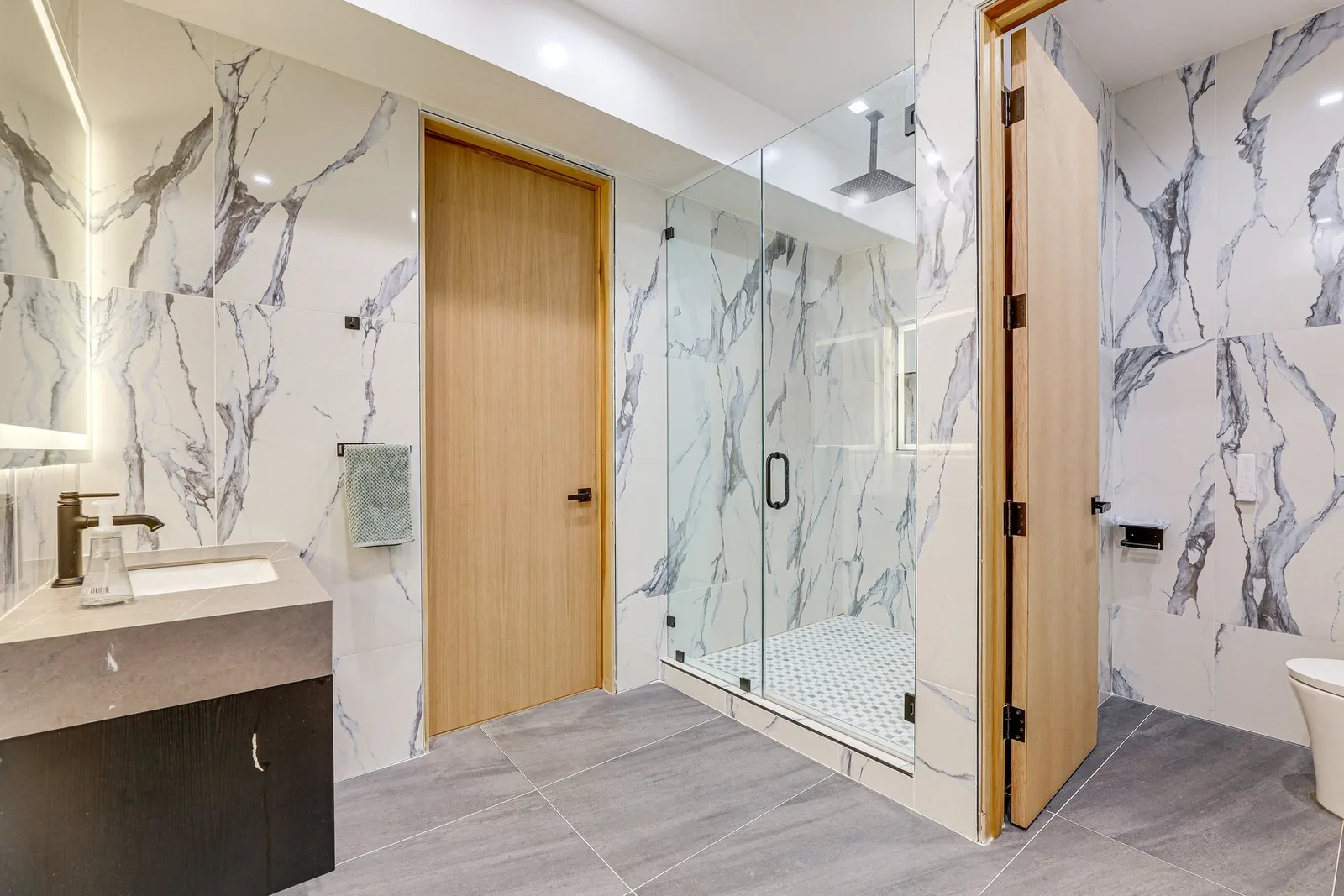 Statuario bath with frameless glass shower